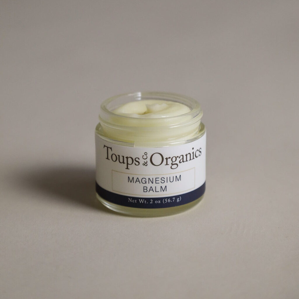 toups and co magnesium balm on a grey counter